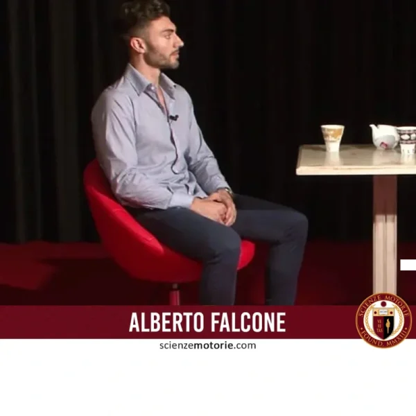 Giovane uomo seduto su poltrona rossa con tavolo, tazza e teiera, fascia bordeaux con nome e logo Scienze Motorie.