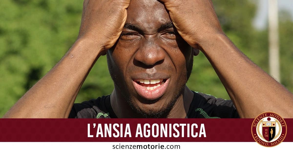 Persona che esprime stress, tenendosi la testa tra le mani, con sfondo verde sfocato. Sotto, la scritta 'L'ANSIA AGONISTICA' e il logo di 'Scienze Motorie.com'