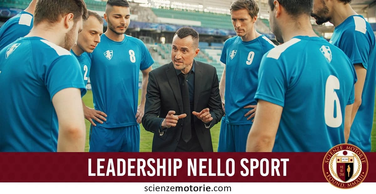 Allenatore in giacca nera che parla con un gruppo di giocatori di calcio con maglie blu su un campo sportivo. Testo in basso: 'LEADERSHIP NELLO SPORT' con il logo di scienzemotorie.com