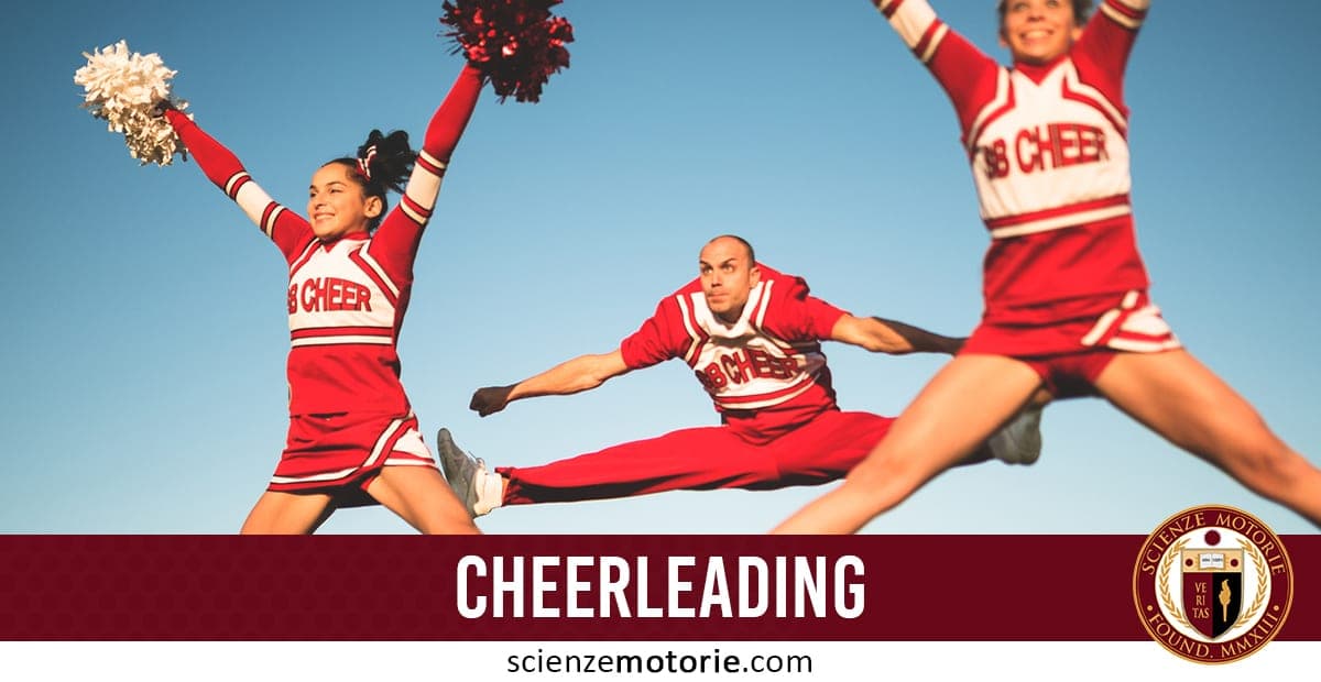 Tre cheerleader in uniforme rossa e bianca eseguono salti acrobatici, con pompon e cielo limpido sullo sfondo.