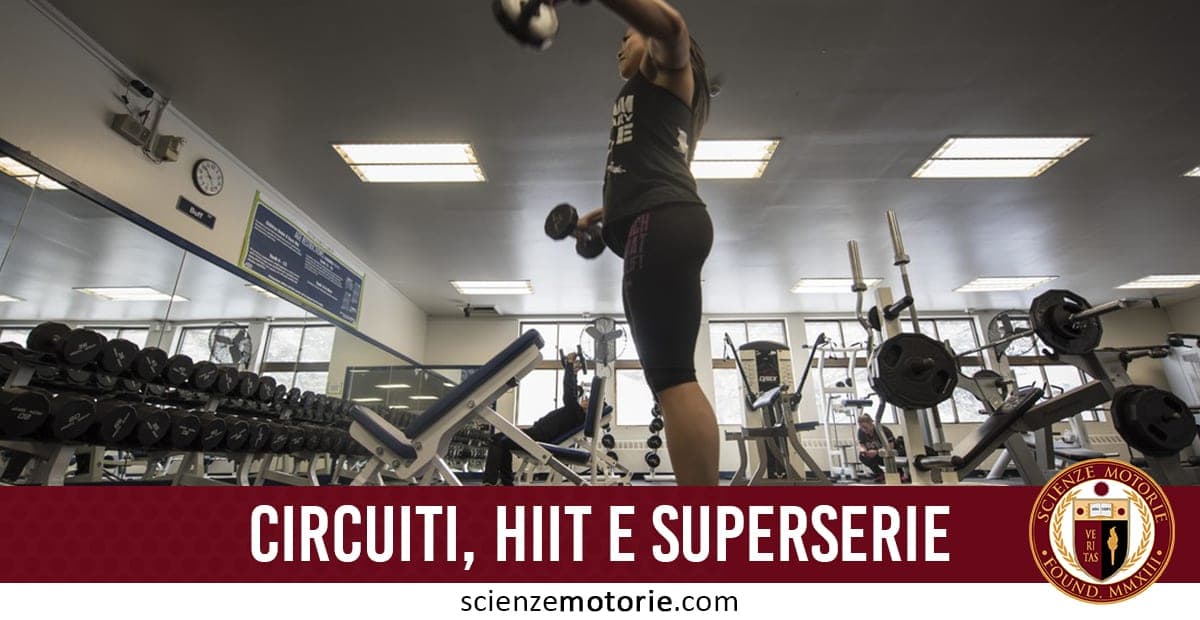 Persona in palestra che solleva pesi circondata da attrezzi fitness come manubri e panche, con testo “CIRCUITI, HIIT E SUPER SERIE” e logo scienzemotorie.com.