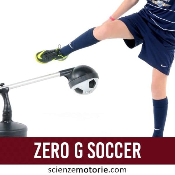 Calciatore in completo blu che calcia un attrezzo di allenamento "Zero G Soccer" con palla montata su braccio meccanico, sfondo bianco, con logo scienzemotorie.com visibile in basso a destra.