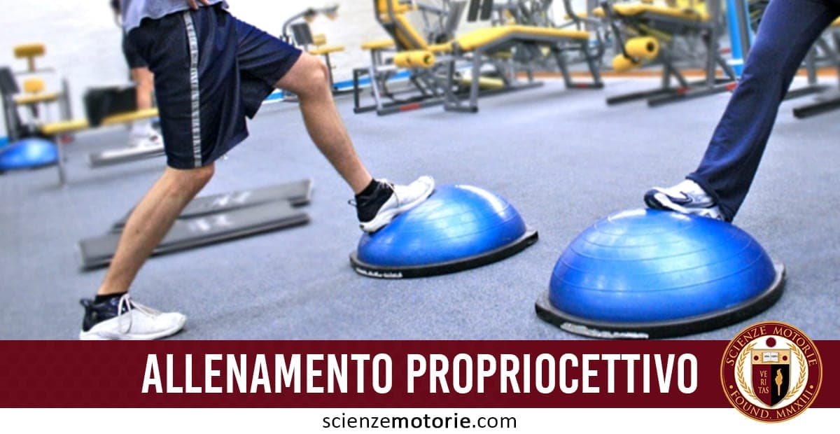 Due persone eseguono esercizi di equilibrio su semisfere blu in palestra per l’allenamento propriocettivo; in basso la scritta "Allenamento Propriocettivo" e il logo scienzemotorie.com.