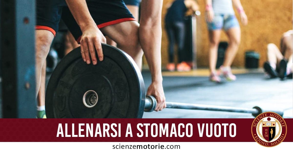 Persona che solleva un bilanciere in palestra, indossa pantaloncini neri con dettaglio rosso; altre persone sfocate sullo sfondo e testo "ALLENARSI A STOMACO VUOTO" con logo Scienze Motorie.