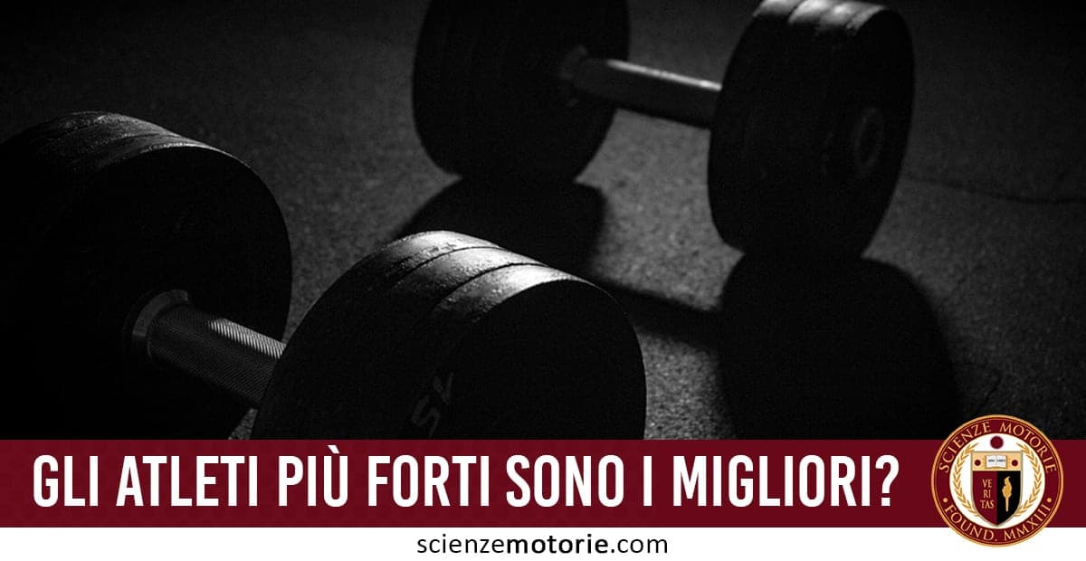 Due manubri posati a terra in una sala fitness con illuminazione scura che crea ombre, testo "GLI ATLETI PIÙ FORTI SONO I MIGLIORI?" e logo Scienze Motorie.