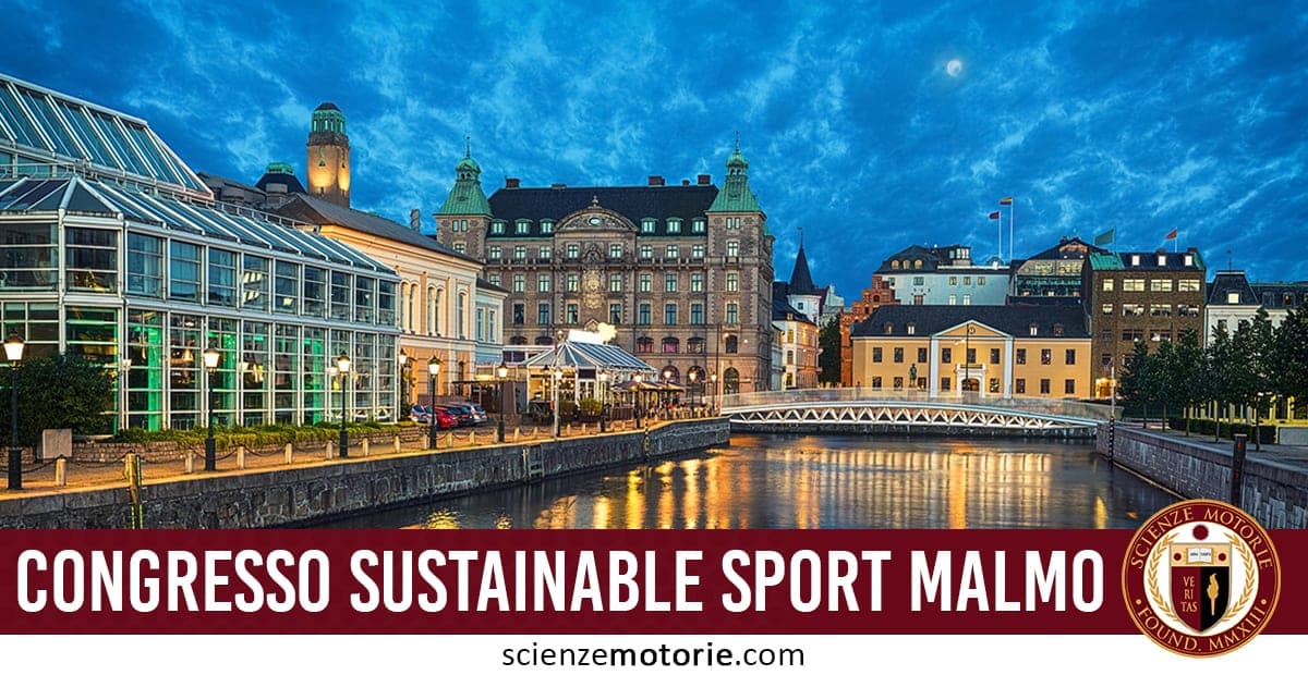 Canale urbano serale a Malmö, Svezia, con edifici illuminati lungo la riva, persone su un ponte e riflessi sull’acqua al crepuscolo.