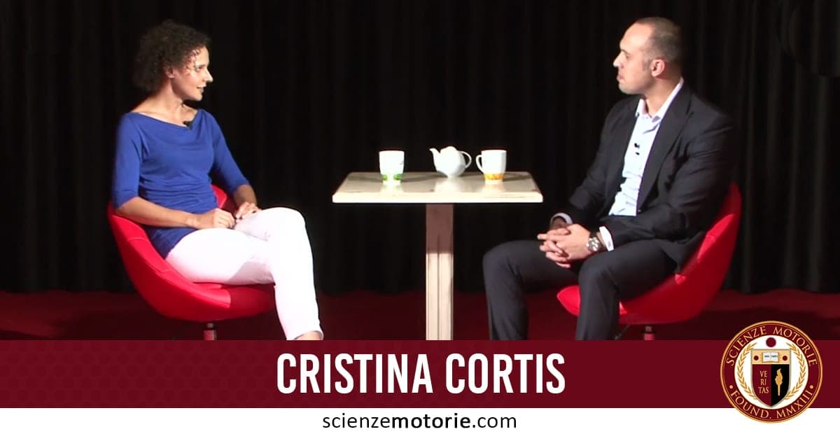 Cristina Cortis in conversazione durante un’intervista per Scienze Motorie, seduta su una sedia rossa con tavolino e tazze.
