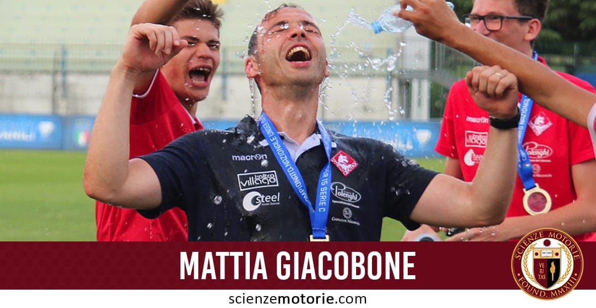 Mattia Giacobone esulta con una medaglia al collo durante una celebrazione sportiva all’aperto, spruzzato con acqua dai compagni.