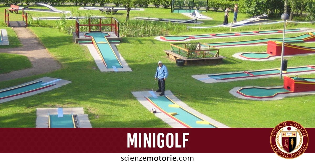 Campo da minigolf con percorsi blu e rossi, persone che giocano su un’area verde.