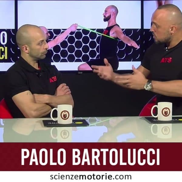 Due persone con magliette ATS sedute a un tavolo con tazze e documenti, davanti a uno schermo che mostra esercizi fisici e il nome Paolo Bartolucci.