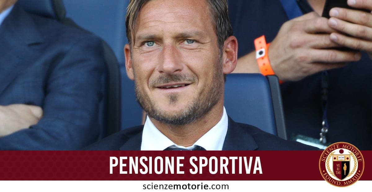 Uomo con giacca e cravatta seduto su una sedia, capelli e barba corti, con persone sfocate sullo sfondo; fascia rossa con scritta “PENSIONE SPORTIVA” e logo di scienzemotorie.com.