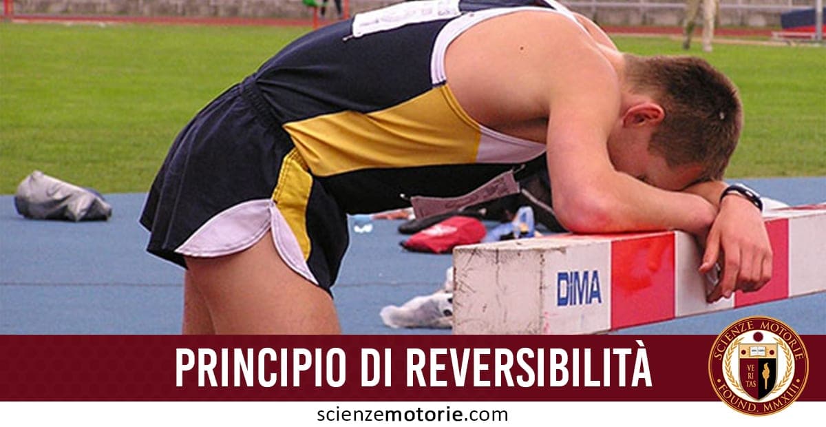 Atleta affaticato appoggiato a una barriera su un campo da atletica, con abbigliamento sportivo. In basso la scritta “PRINCIPIO DI REVERSIBILITÀ”, logo Scienze Motorie e sito scienzemotorie.com.