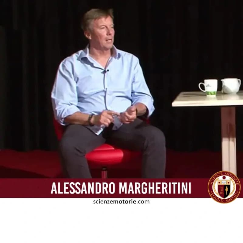 Alessandro Margheritini seduto su poltrona rossa con tavolino e tazze bianche, fascia bordeaux con nome e logo Scienze Motorie.